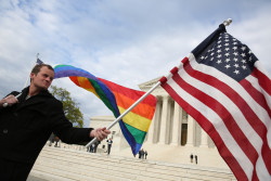 A support of marriage equality stands with a rainbow flag and a United States flag near protestors on the steps of the United States Supreme Court ahead of oral arguments in three landmark same-sex marriage cases. Plaintiffs in the Tanco vs. Haslam case, the lead case for same-sex marriage in Tennessee, meet with members of the media on the steps of the United States Supreme Court in Washington, DC on Monday, April 27, 2015.